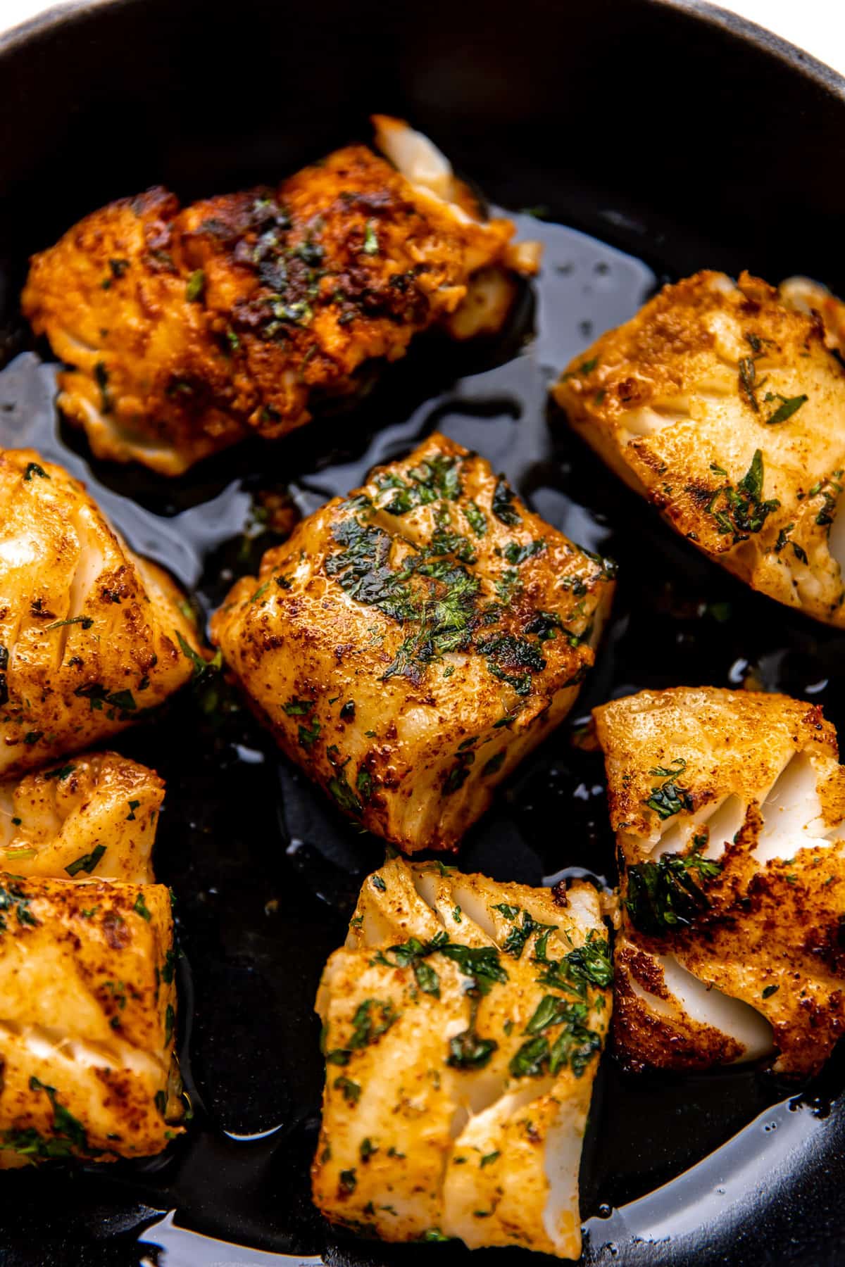 Fish searing in a cast iron skillet.