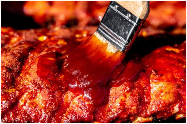 Brushing ribs with sauce.