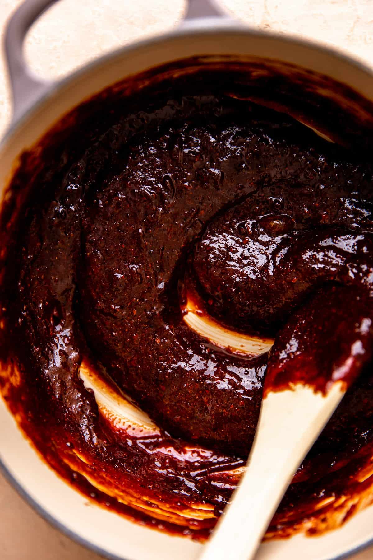 Thick chamoy rim dip being stirred in a small dutch oven.