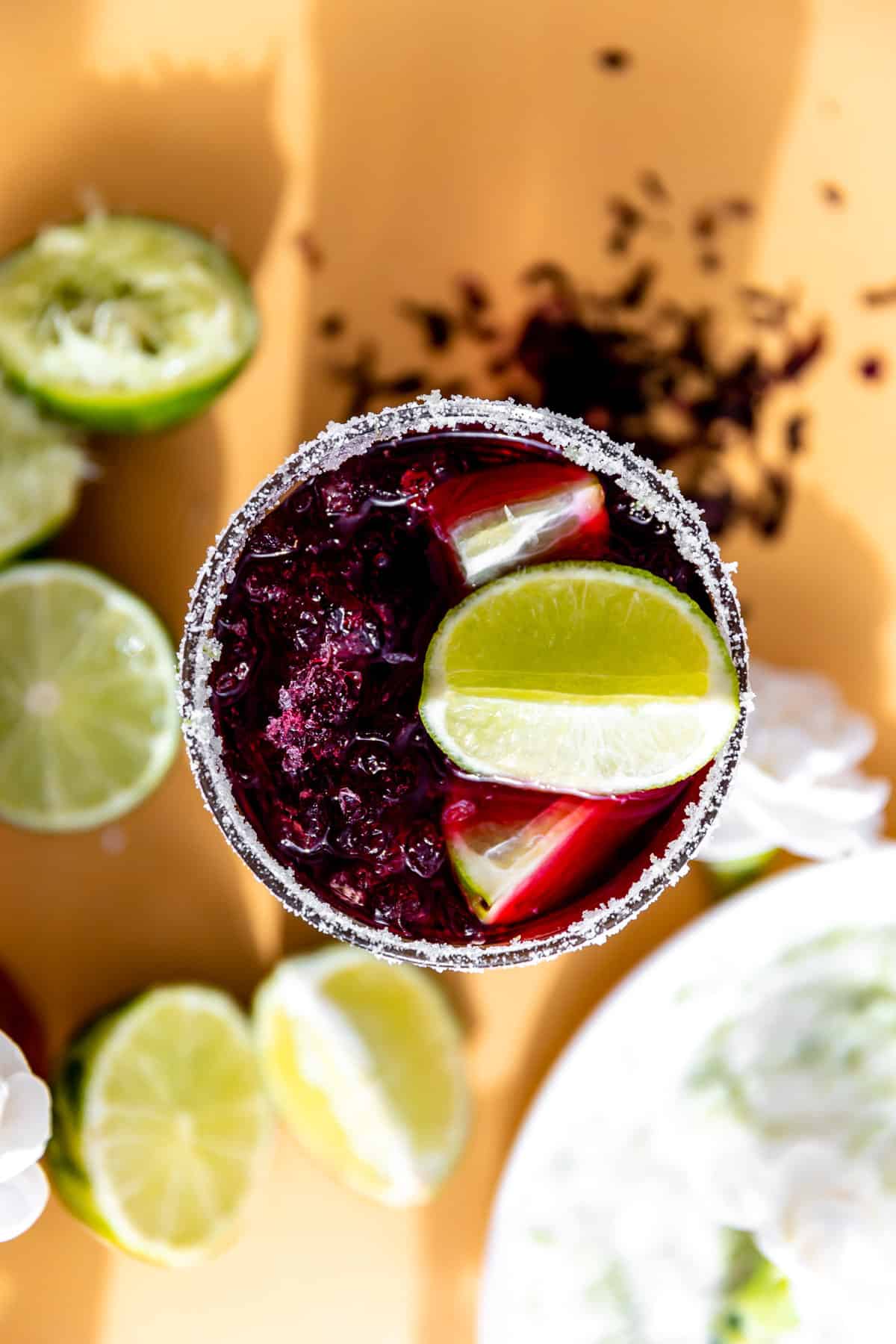 Overhead view of a hibiscus margarita topped with a lime wedge. 