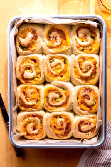 Baking dish with baked jalapeño cheese rolls.