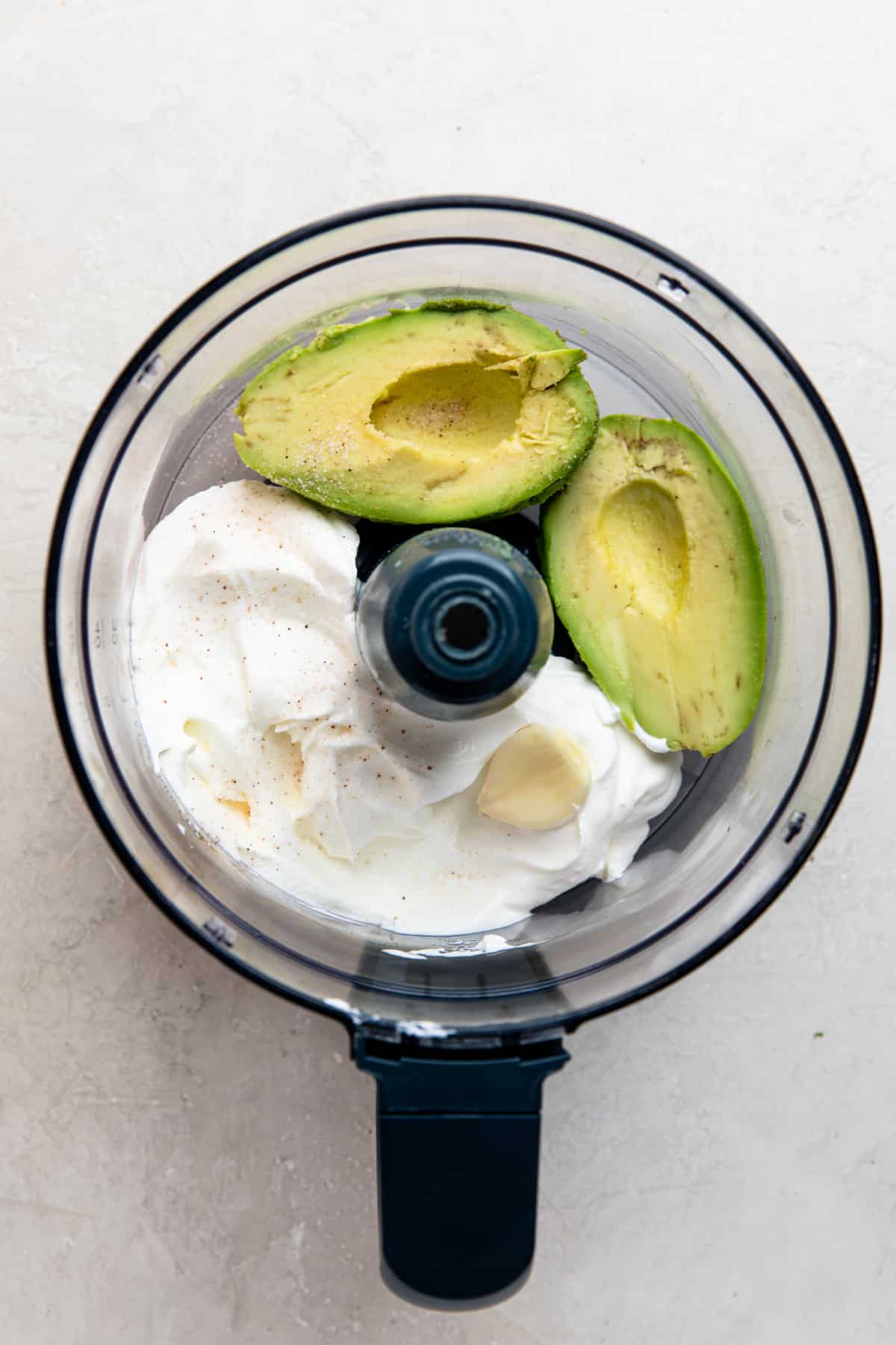 Ingredients for avocado crema in a food processor before blending.