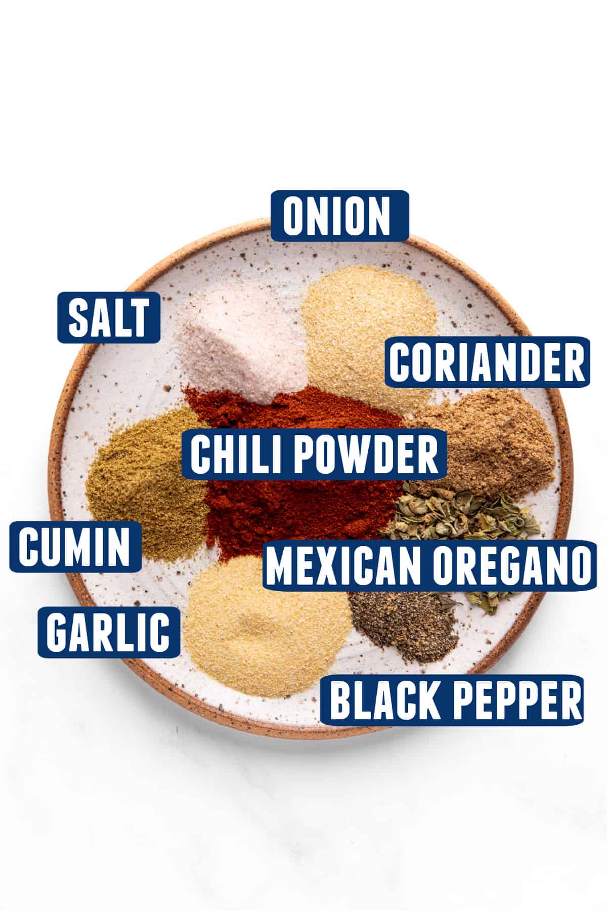 Ingredients needed to make carnitas seasoning mix all laid on a plate.
