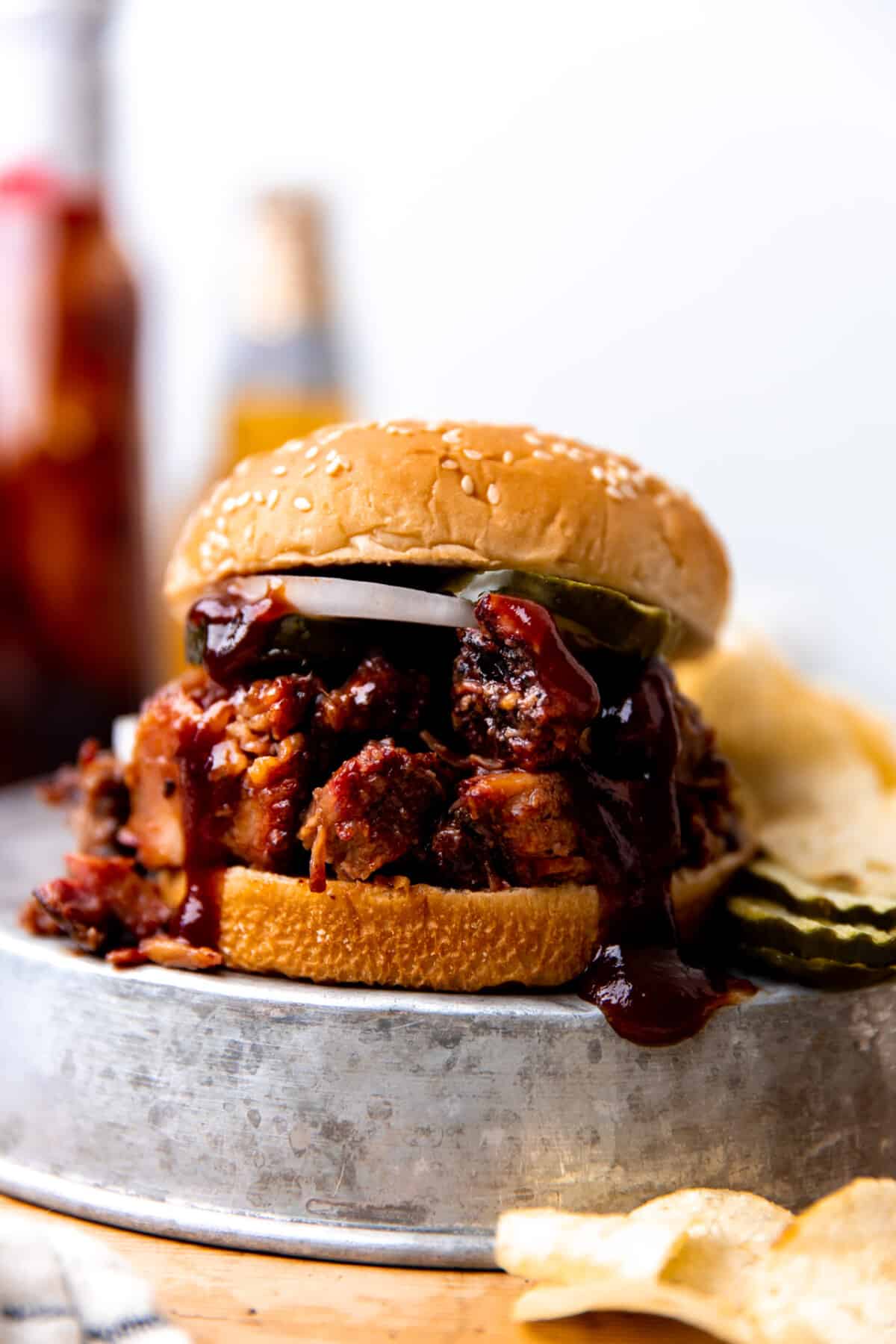 Beef with bbq sauce and white onions on a hamburger bun.