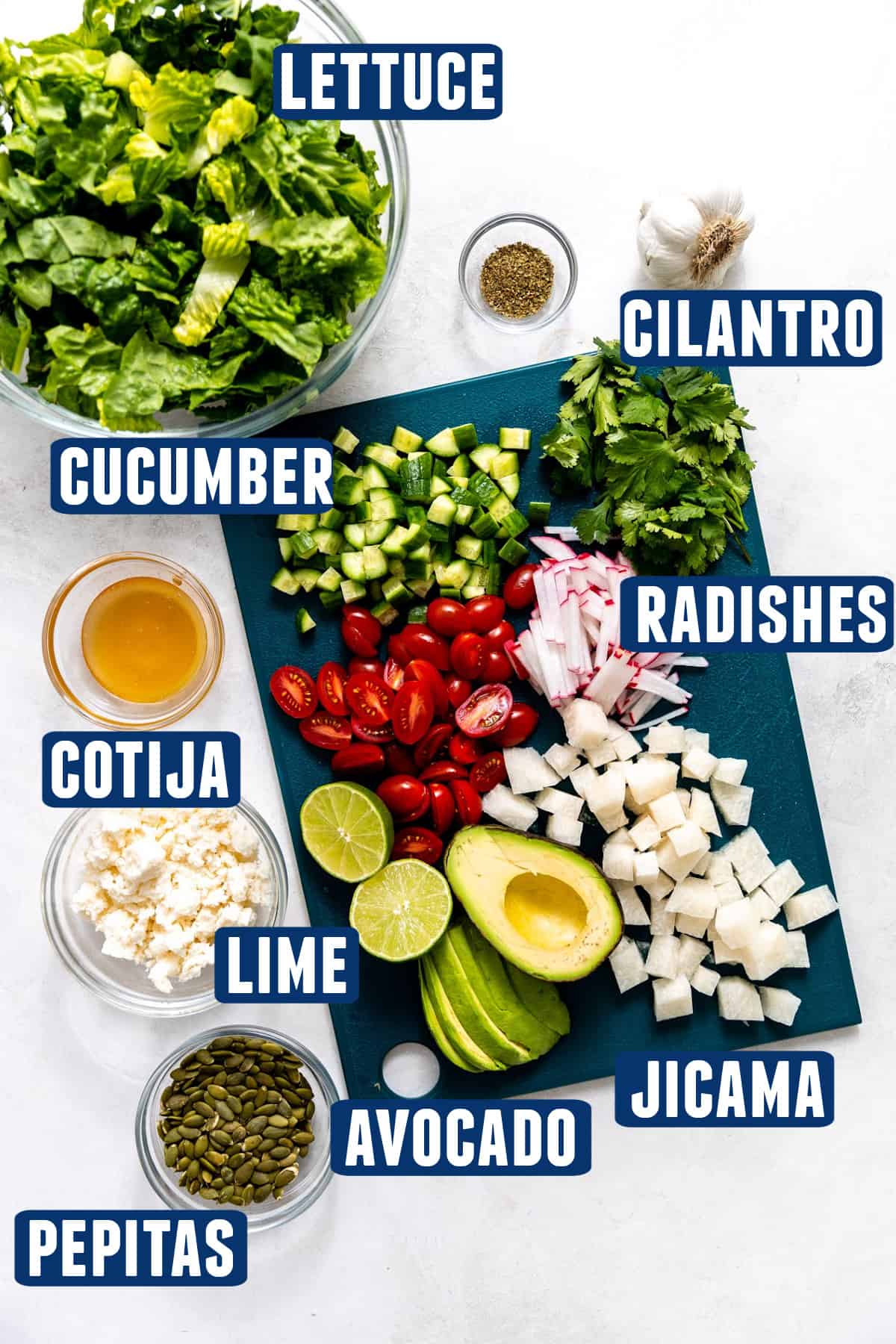 Ingredients needed to make a mexican salad laid out on the counter, vegetables on a cutting board that have been chopped.