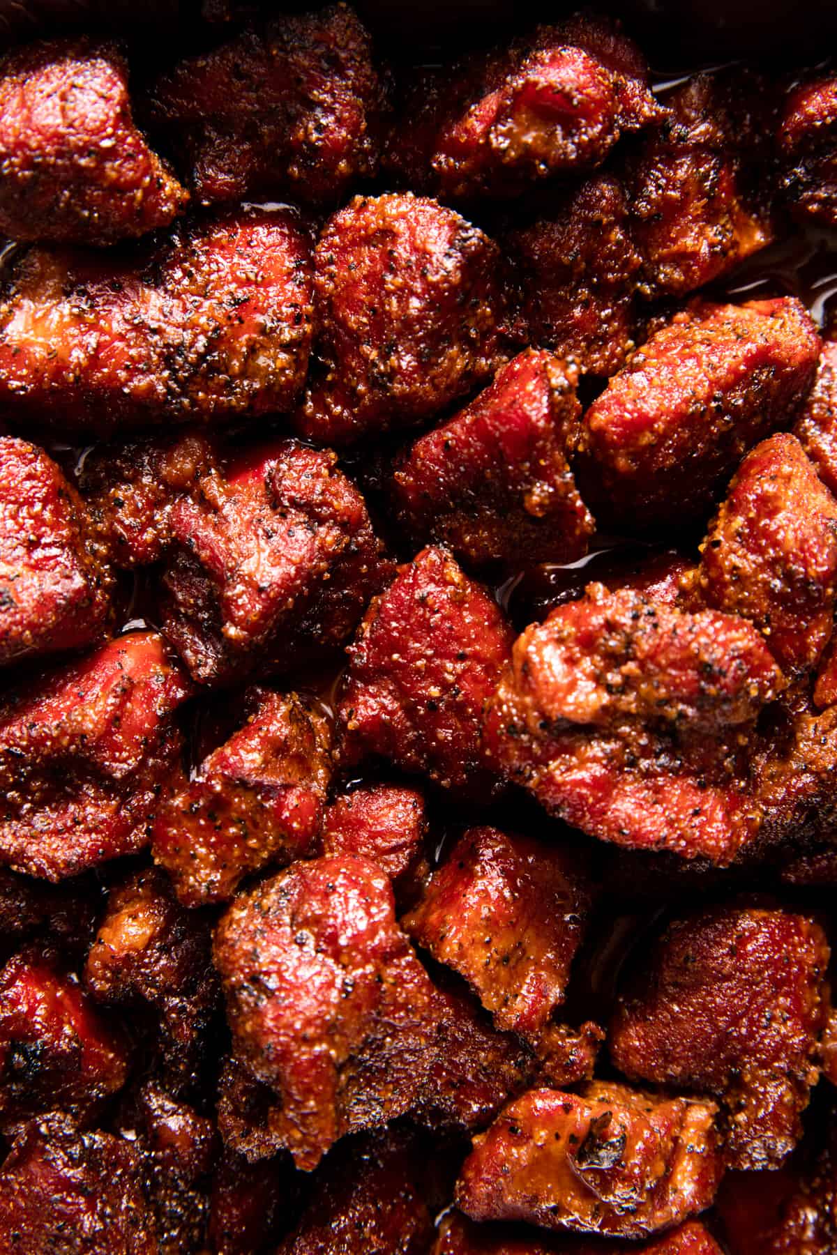 Up close image of smoked chuck roast coated in sticky, sauce for poor man's burnt ends.