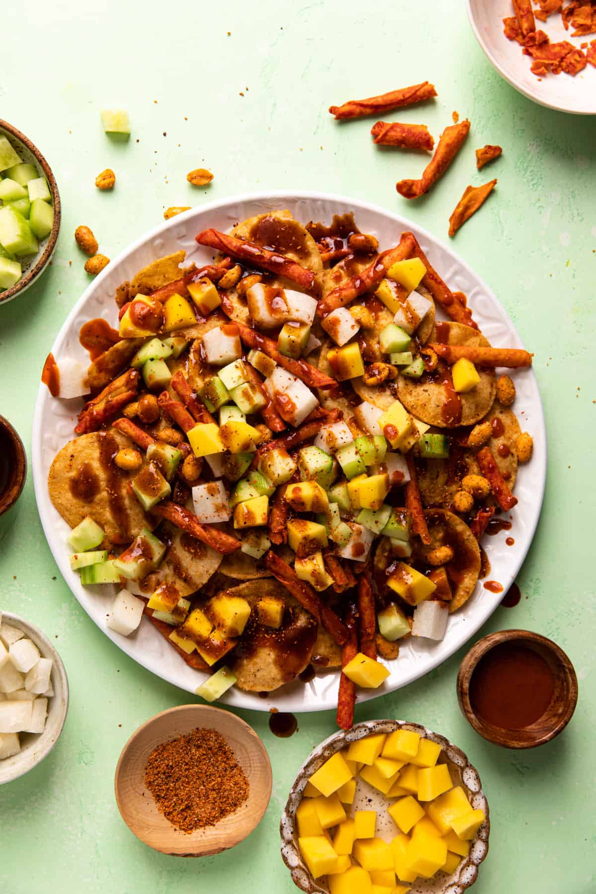 Plate of prepared Tostilocos with hot sauce and chamoy drizzled on top.