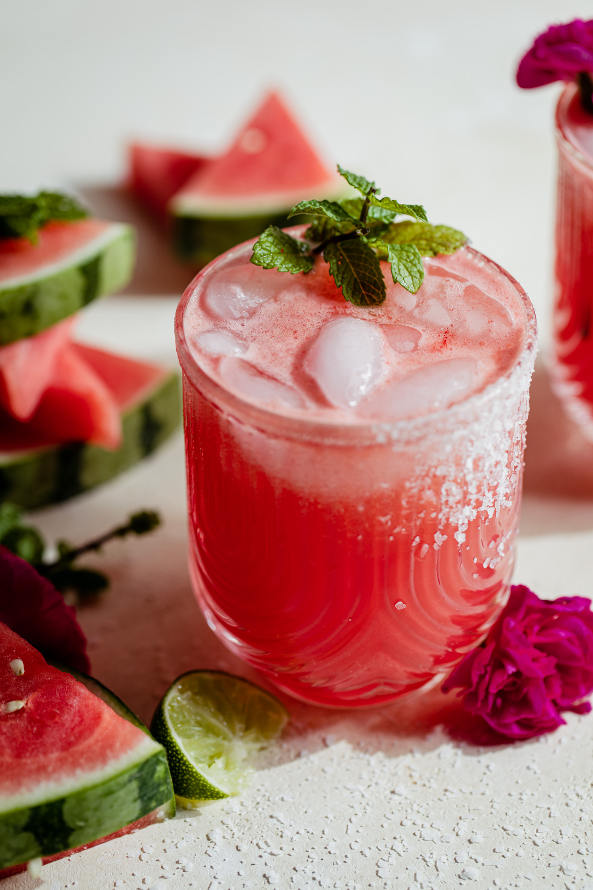 Glass filled with pink watermelon margarita with salt on the rim.