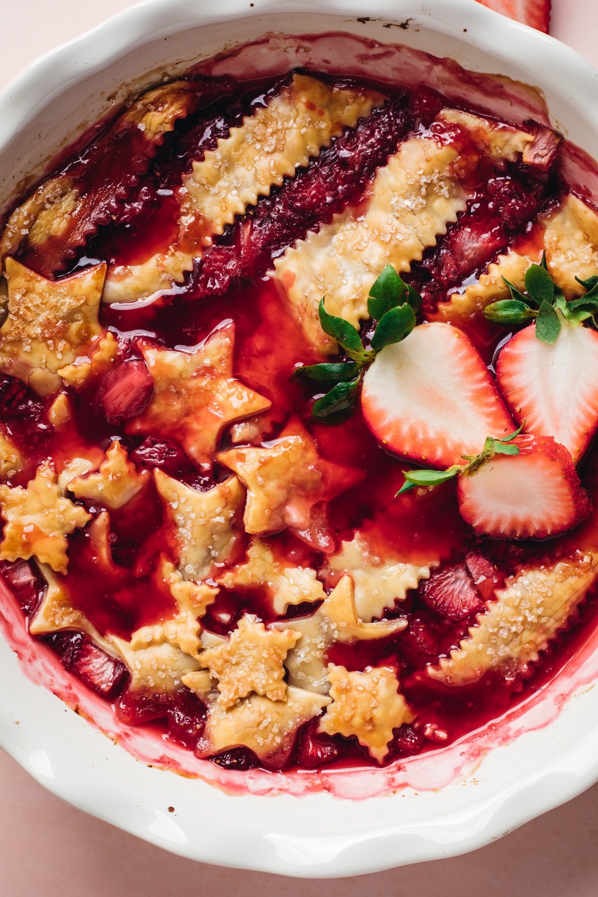 Up close view of American strawberry cobbler baked with Stars and Stripes in pie crust on top.