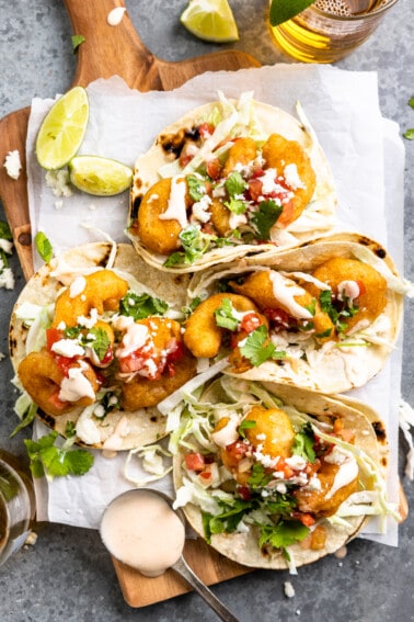Tortillas filled with fried shrimp, creamy slaw, and topped with fish taco sauce.