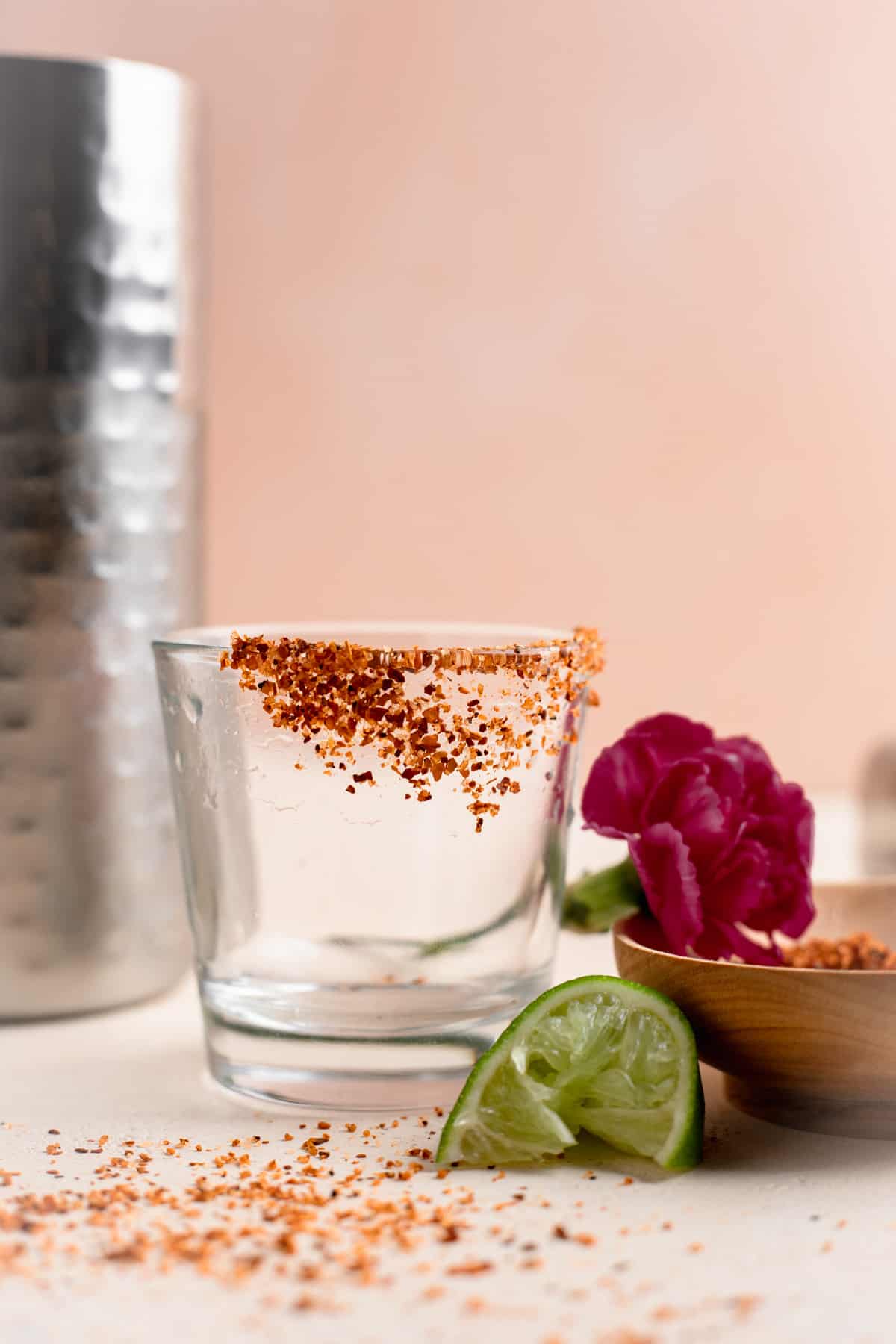 Shot glass rimmed with tajin with a lime wedge on the side. 