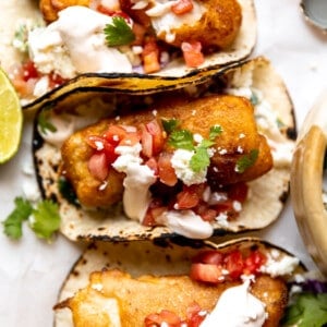 Baja Fish Tacos served with charred corn tortillas, and topped with Pico de Gallo, crema, and crumbled queso fresco.