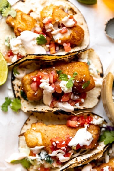 Baja Fish Tacos served with charred corn tortillas, and topped with Pico de Gallo, crema, and crumbled queso fresco.