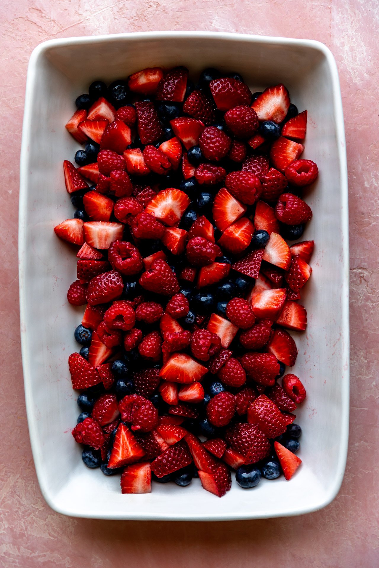 Berries in a white baking dish. 