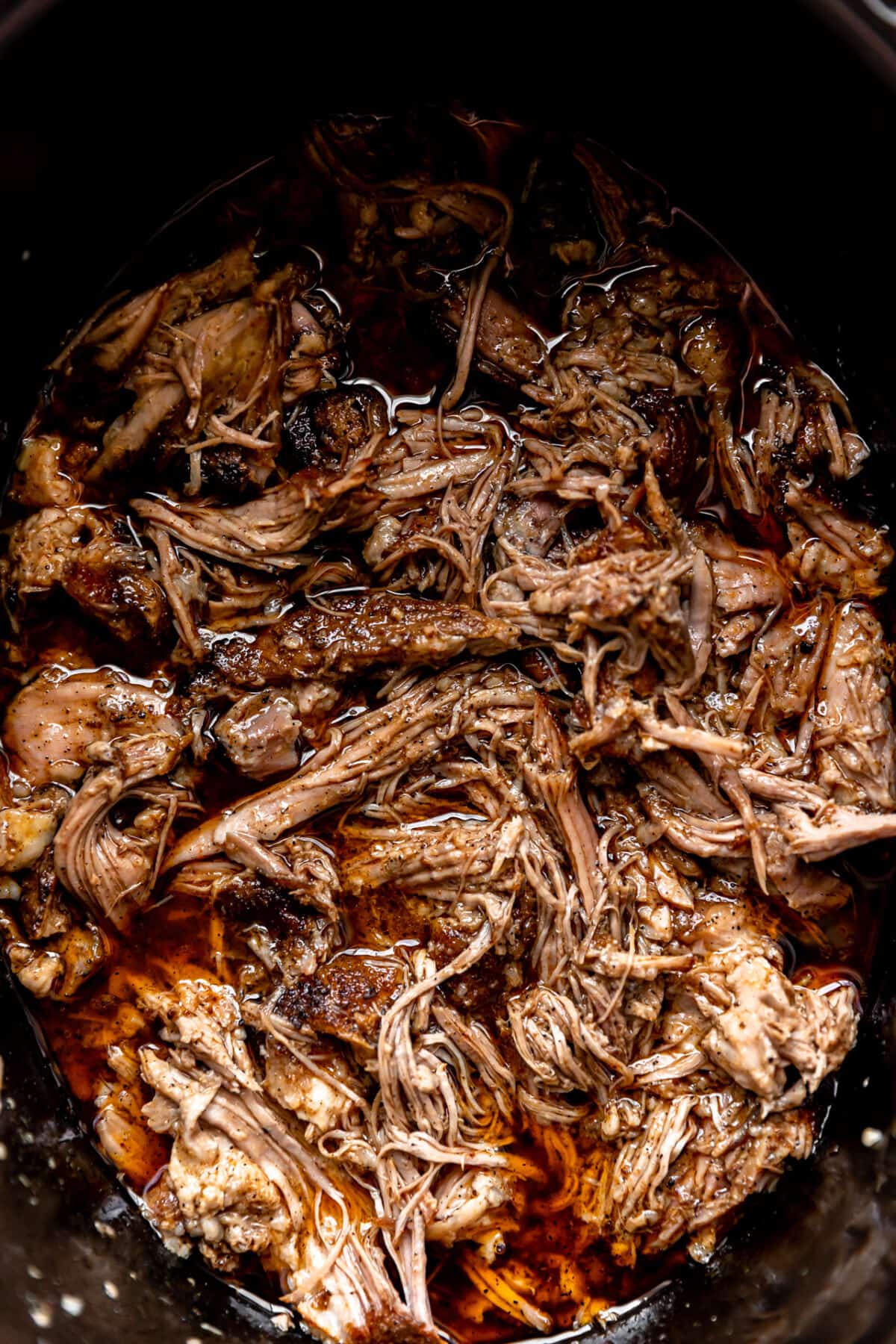 Up close of pulled pork in a slow cooker.