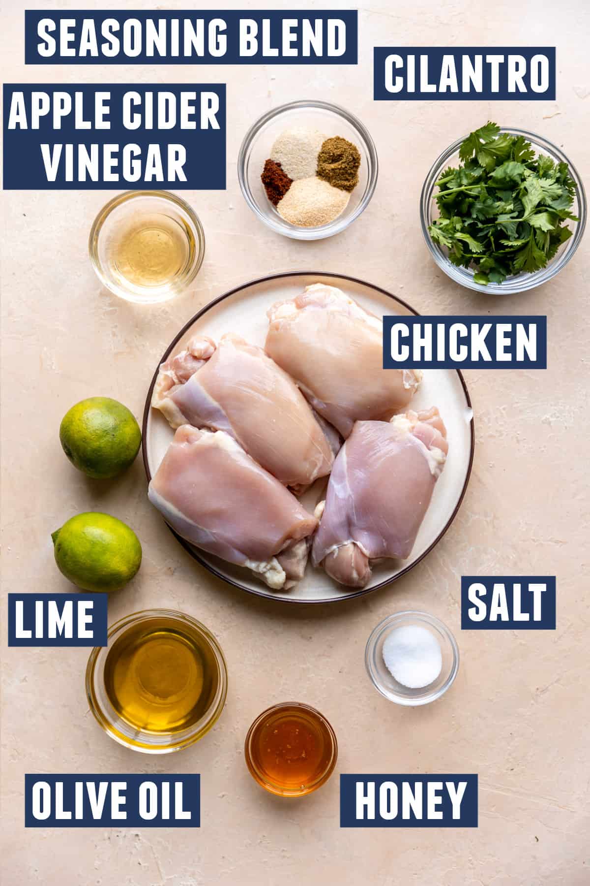 Ingredients needed to make mexican chicken marinade laid out on the counter with a plate of chicken thighs.