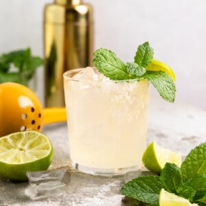 Glass filled with margarita and garnished with mint leaves.