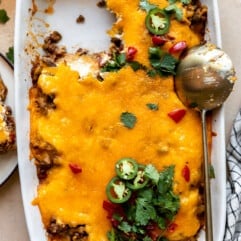 Baking dish with John Wayne Casserole with a portion served and a golden spoon on the side.