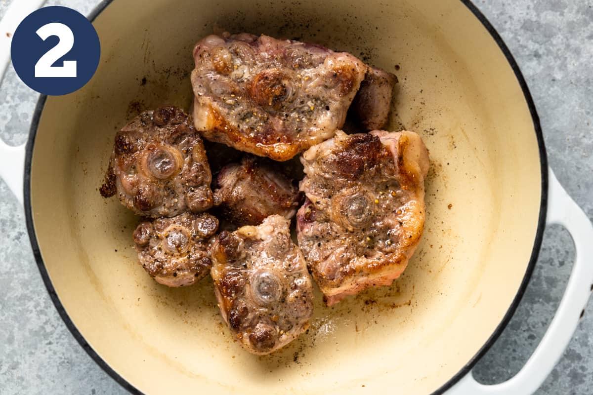 Seared oxtails in a dutch oven.