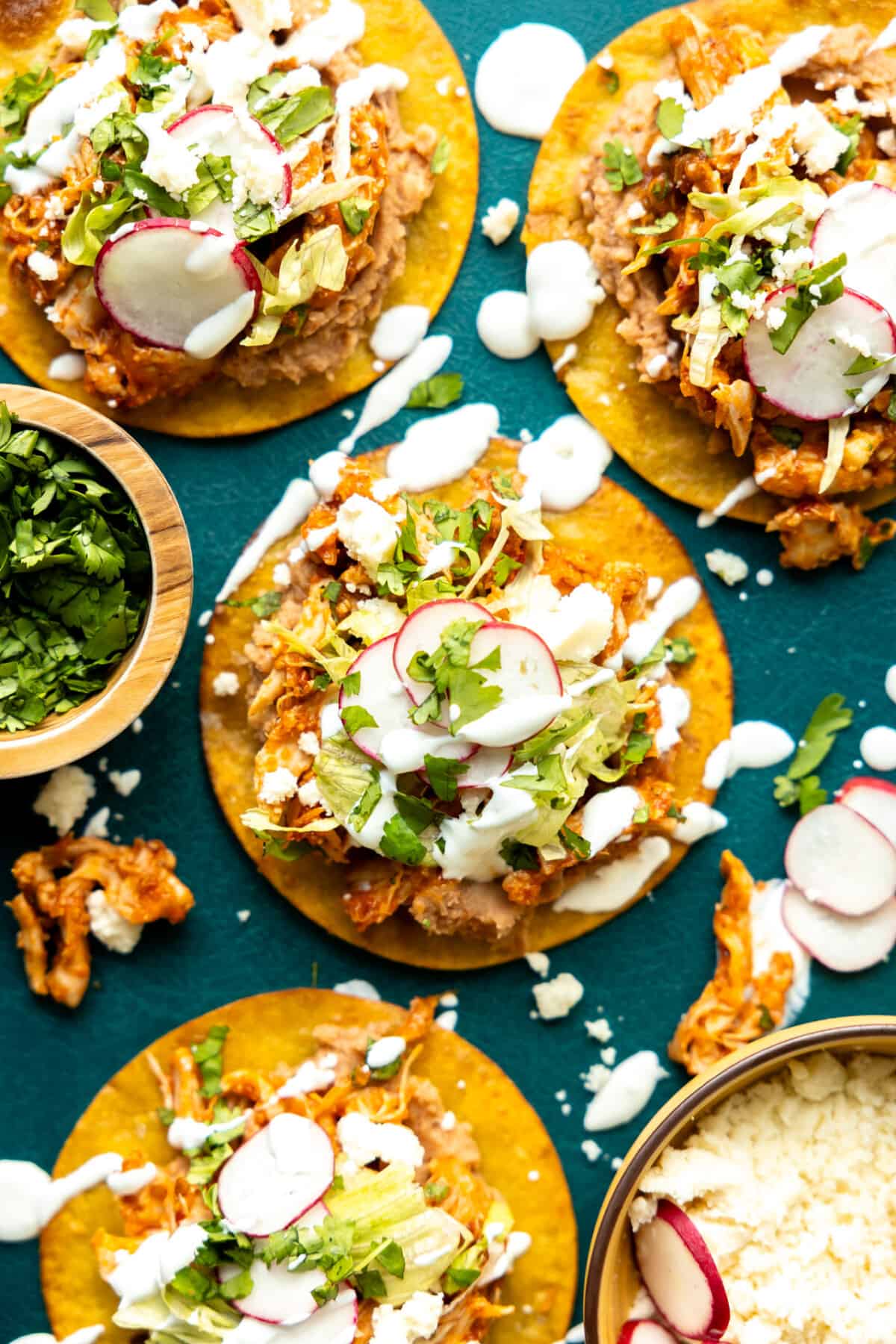 Homemade tostadas topped with chicken Tinga drizzled with crema. 