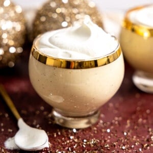 Glass of eggnog topped with whipped cream.