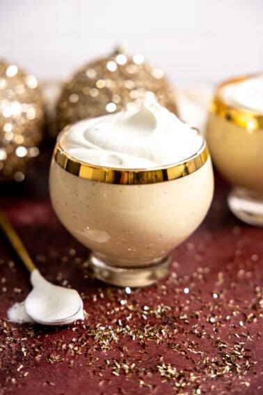 Glass of eggnog topped with whipped cream.