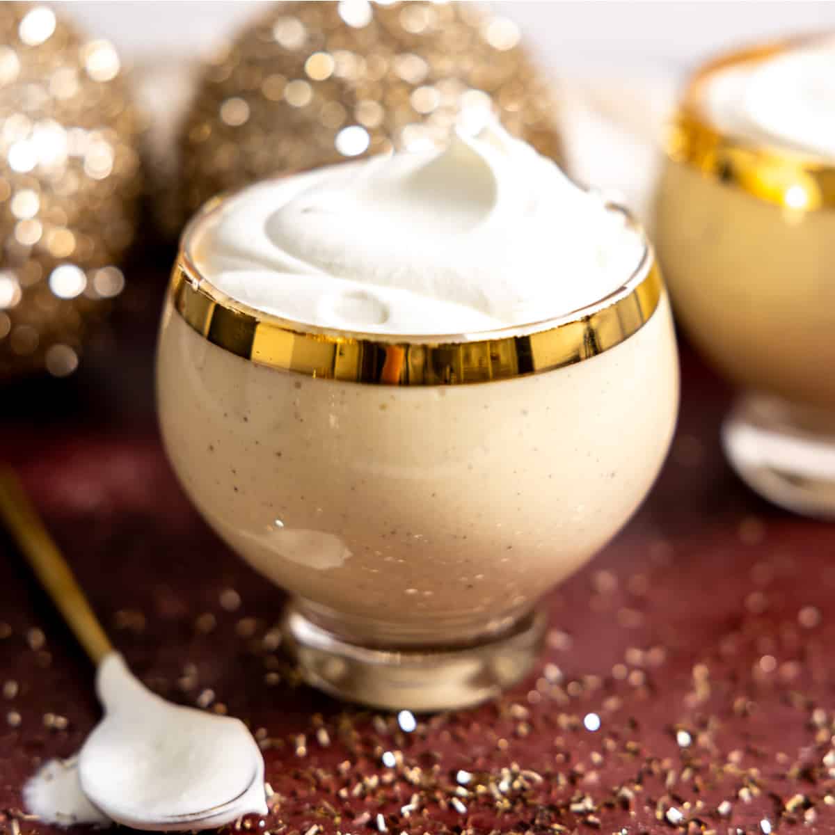 Glass filled with eggnog and topped with whipped cream.