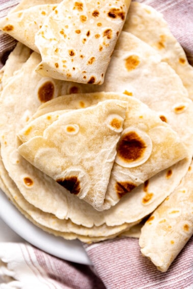 Plate filled with homemade flour tortillas.