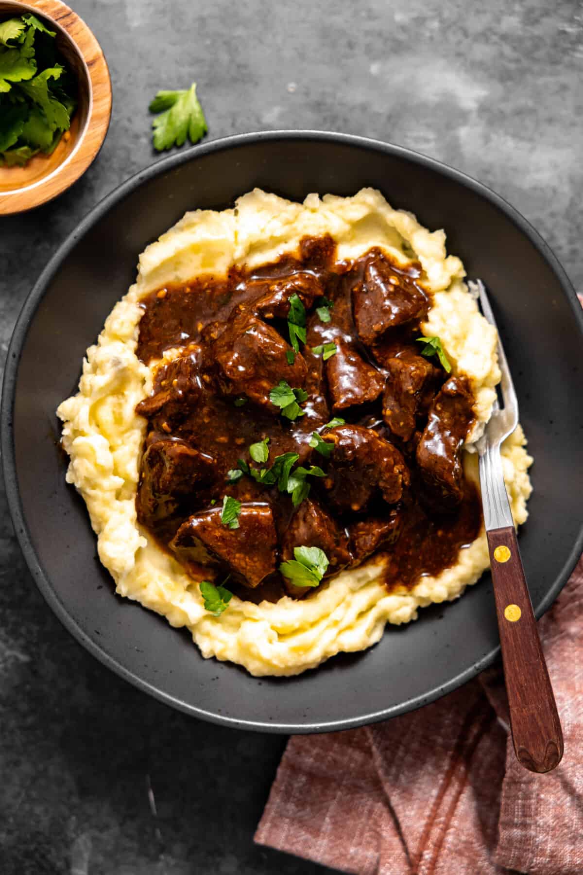 Bowl with mashed potatoes topped with beef tips and gravy.
