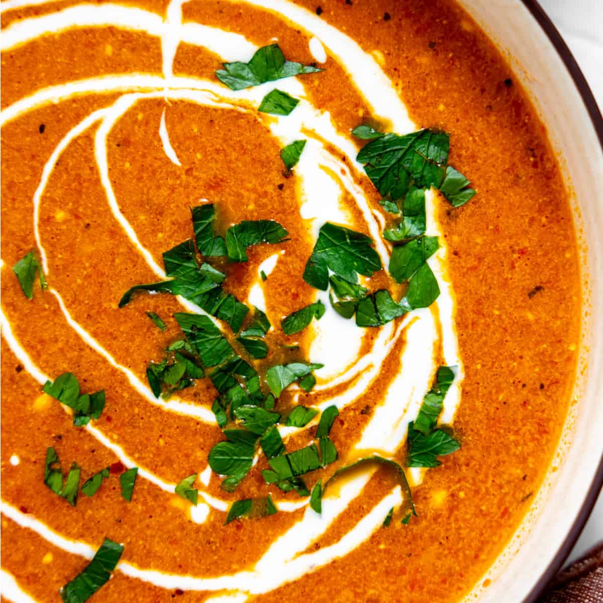 Roasted red pepper soup topped with sour cream and herbs.
