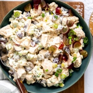 Bowl of chicken salad topped with grapes.