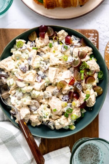 Bowl of chicken salad topped with grapes.