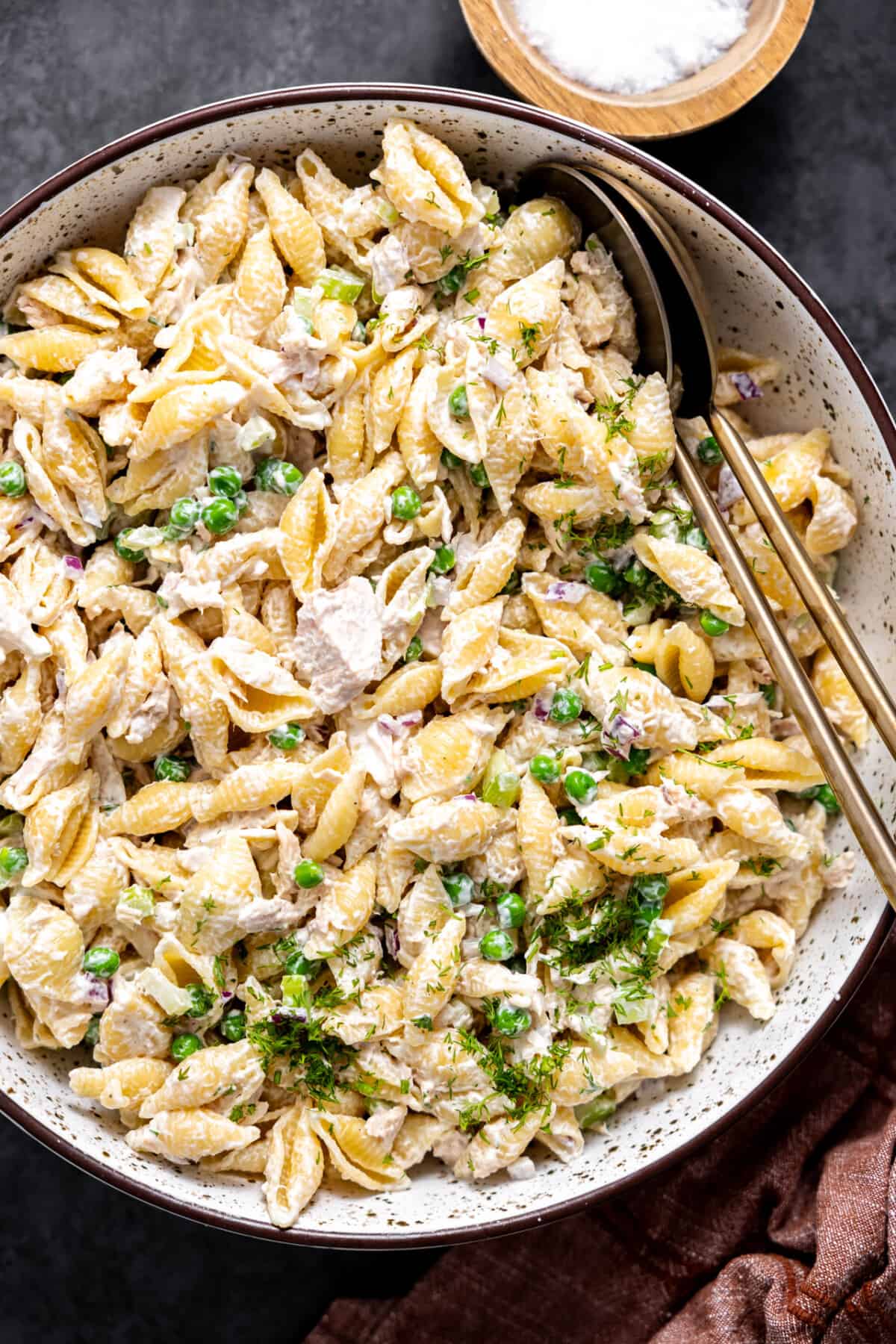 Bowl of tuna pasta salad with spoons for serving. 