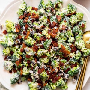 Broccoli salad topped with bacon served on a plate.