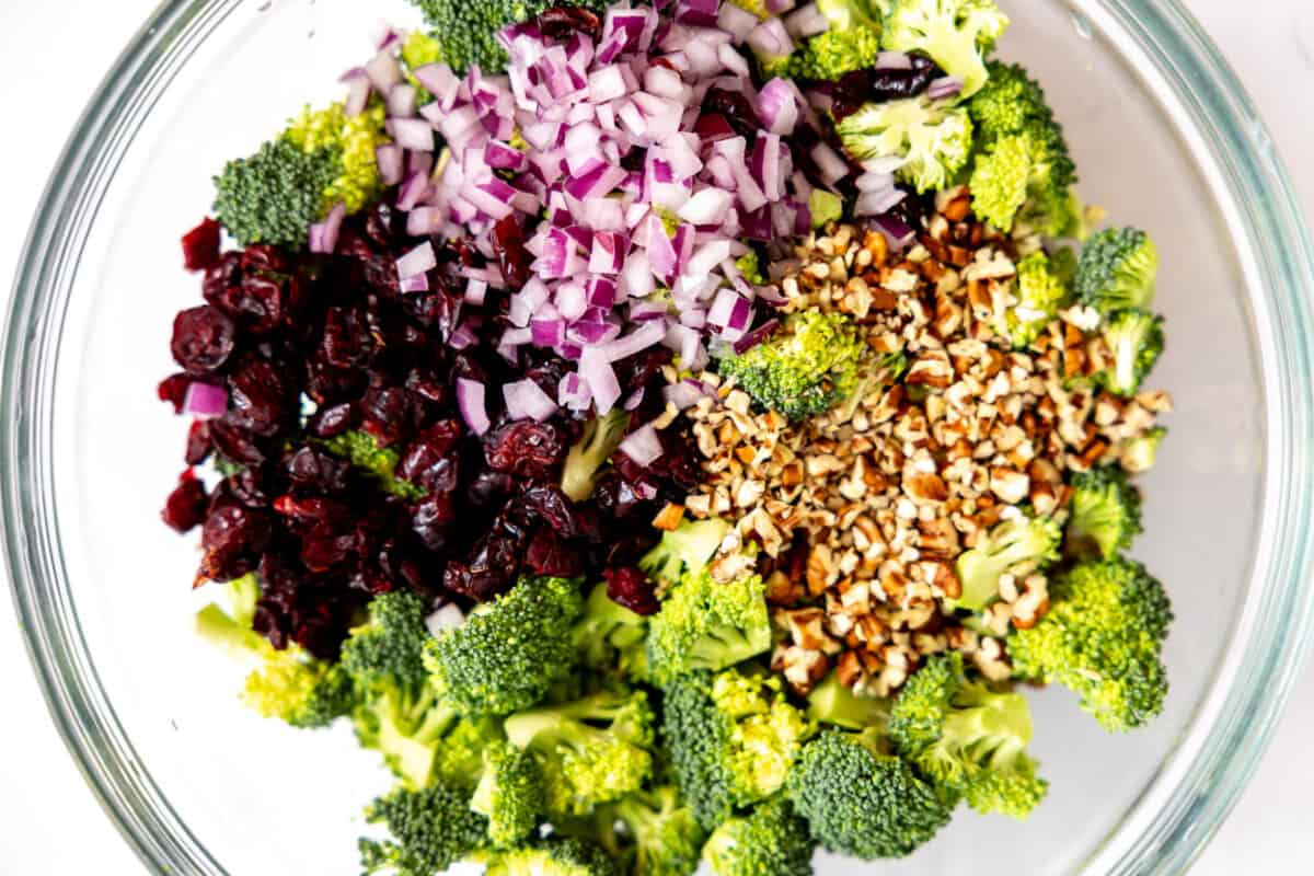 Bowl filled with ingredients for making broccoli salad.