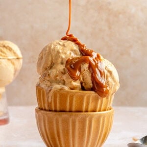 Drizzling caramel on a bowl of homemade ice cream.