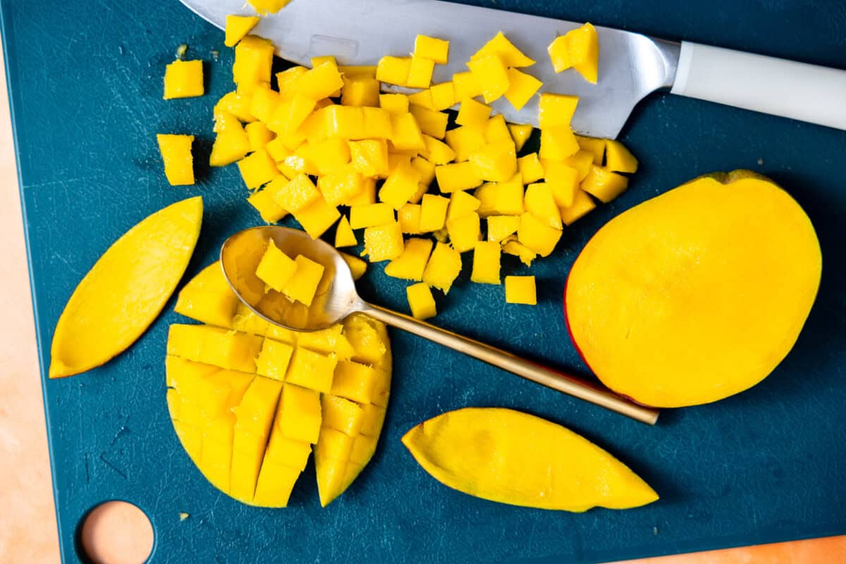 Mango being diced on a cutting board.