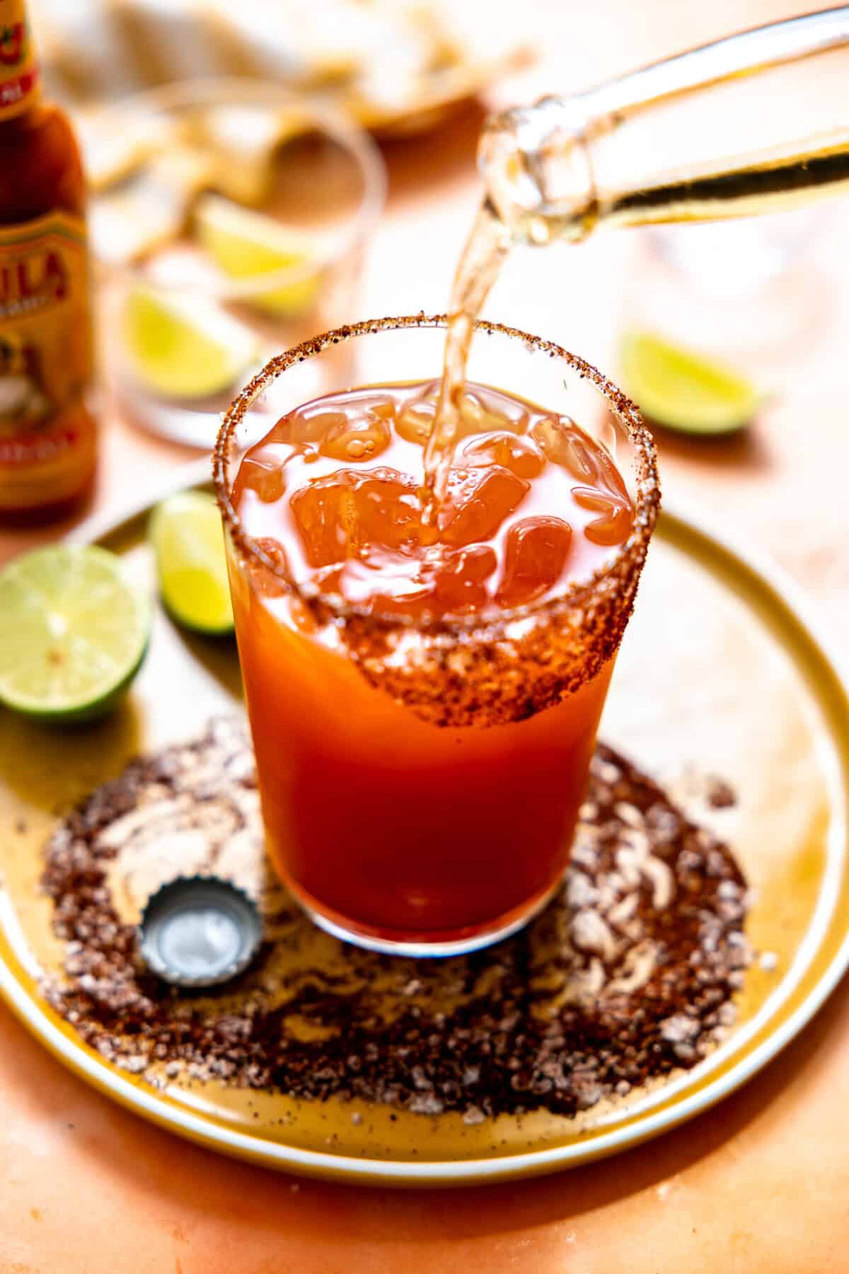 Pouring beer into a Michelada. 