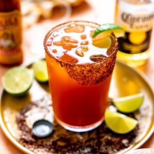 Michelada served with lime wedges.