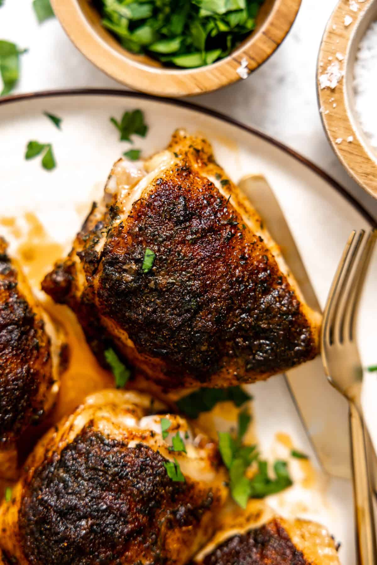 Baked chicken thighs served on a plate. 