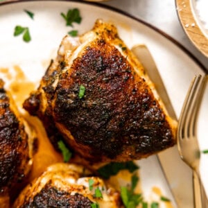 Baked chicken thighs served on a plate.