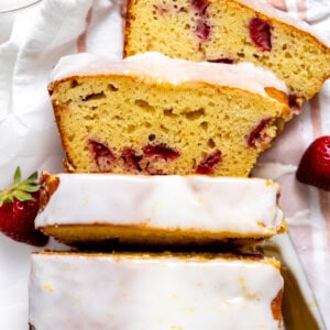 Sliced Strawberry Lemon Loaf Cake topped with a lemon glaze.