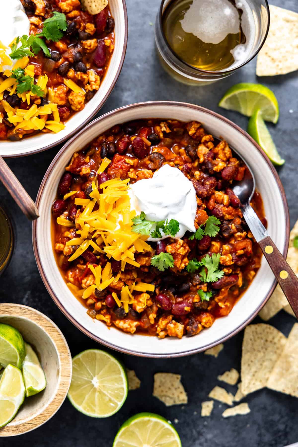 Bowl of turkey chili served with cheese and sour cream on top.