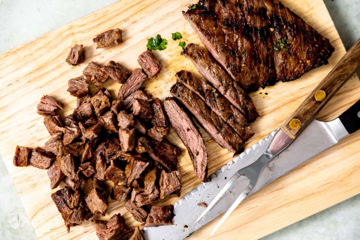 Chopped carne asada on a wooden cutting board.