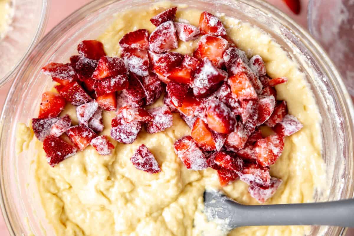 Adding strawberries to a lemon loaf batter. 