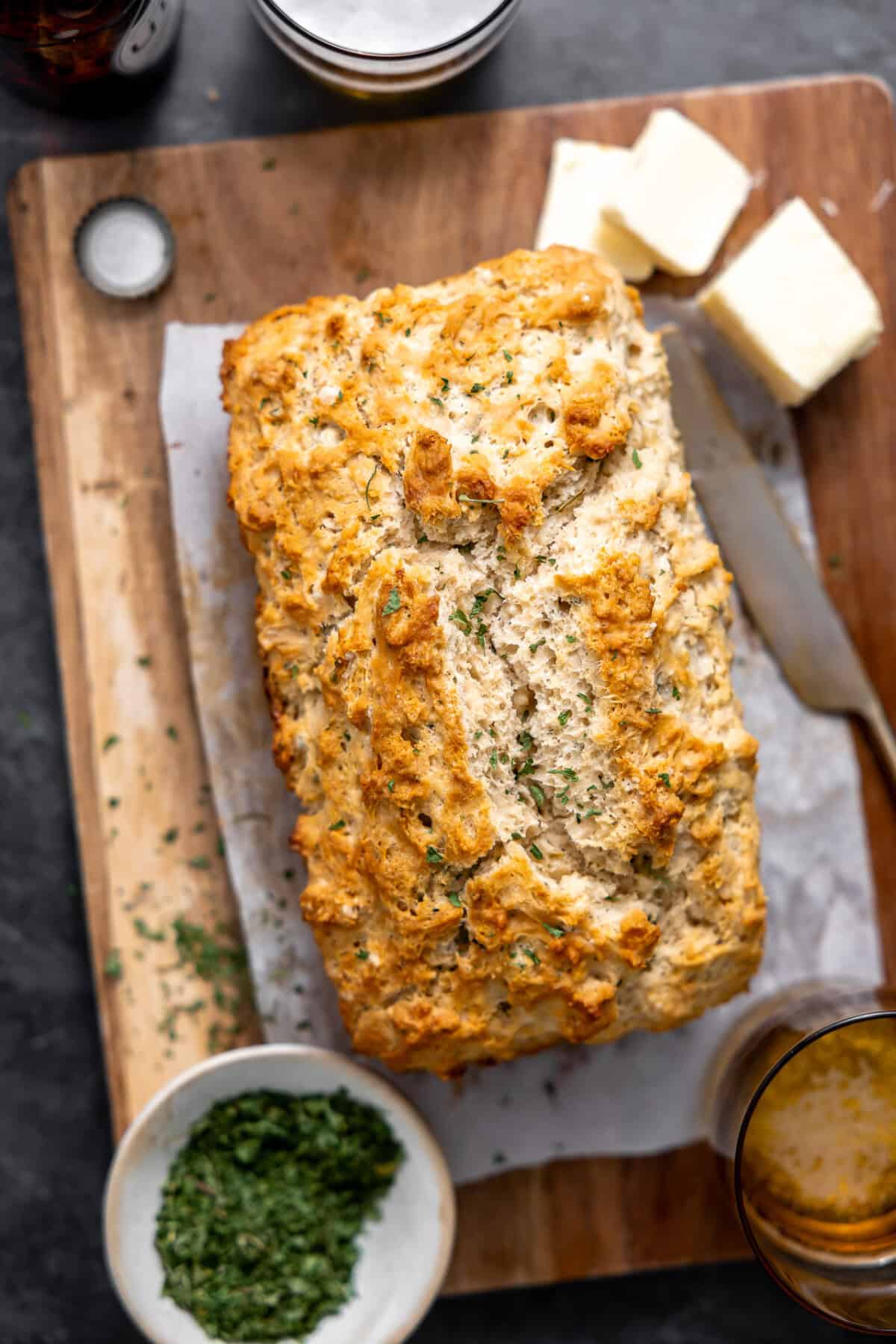 Loaf of baked beer bread on a cutting board. 