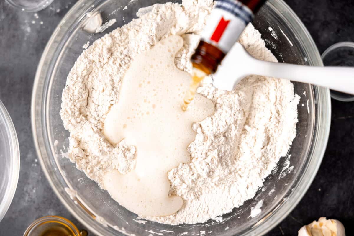 Pouring beer into dry ingredients to make beer bread batter. 