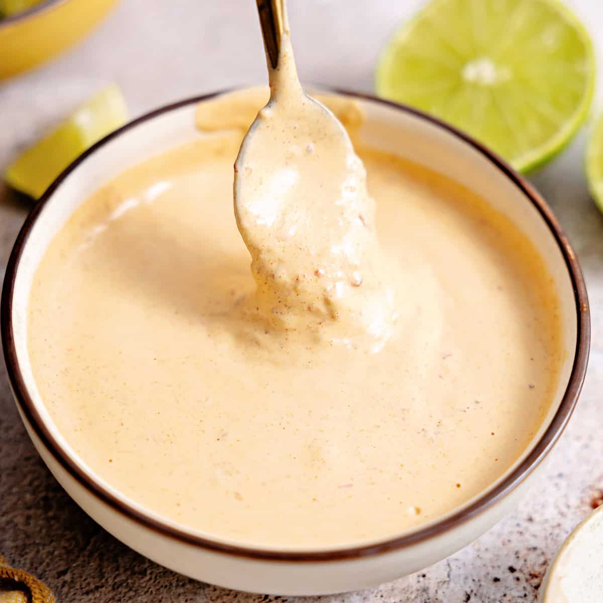 Bowl with chipotle mayo being drizzled with a spoon.