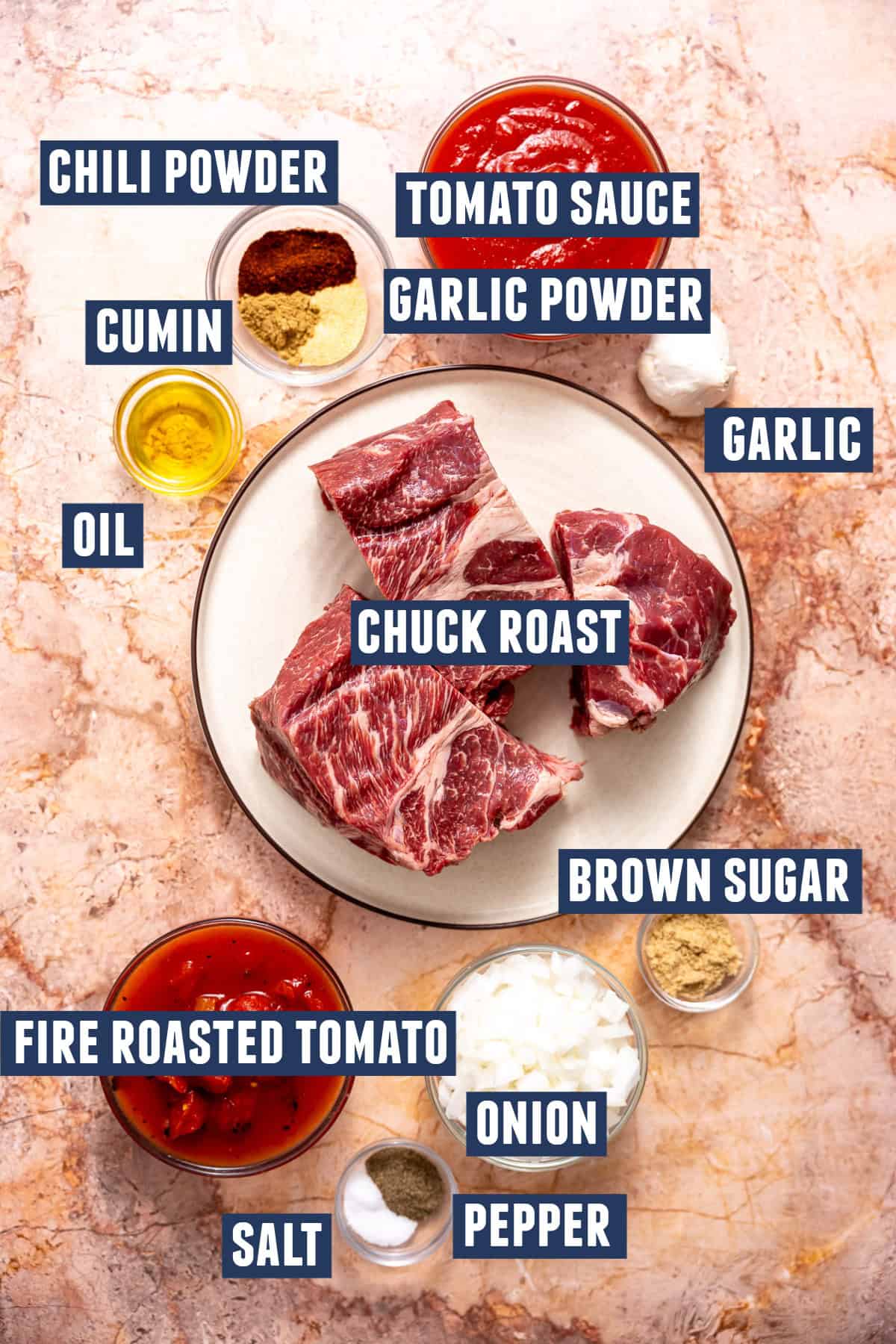 Ingredients needed to make Chuck Roast Chili including: chuck roast, onion, garlic, tomato sauce, fire-roasted tomatoes, oil, and spices. 