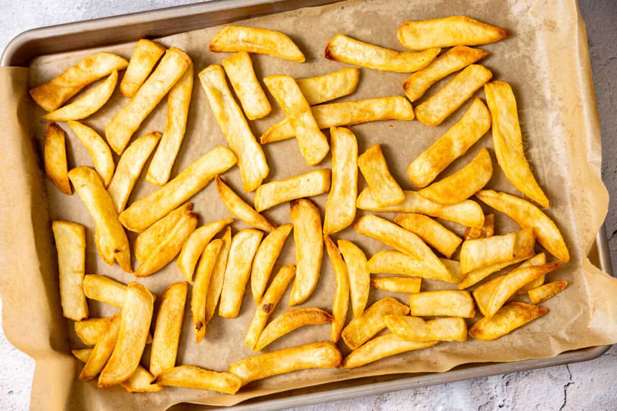 French fries on a baking sheet after baking and getting crispy. 